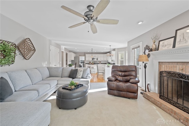 living room with recessed lighting, a fireplace, light colored carpet, and a ceiling fan