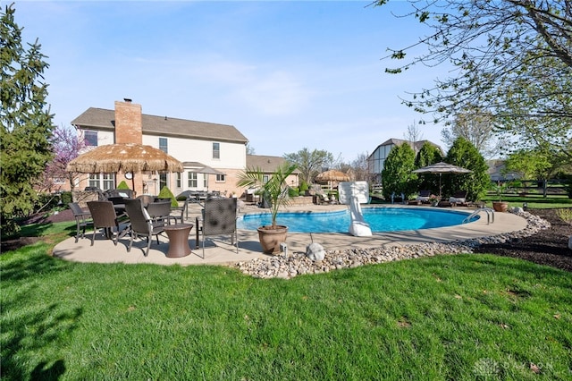 pool with a yard and a patio