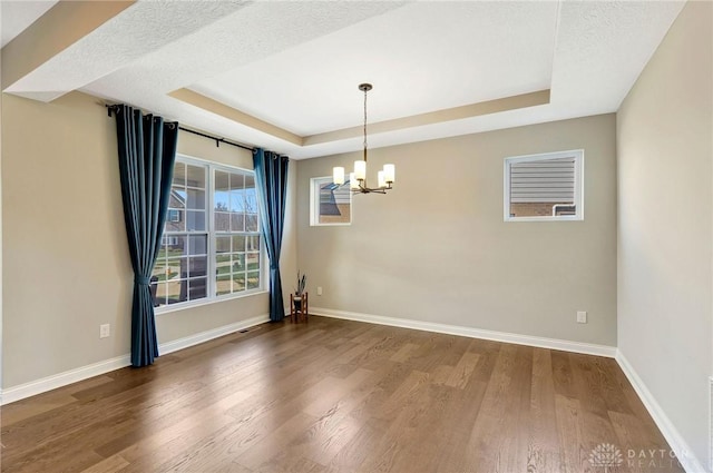 1490 Dell Glen Rd, Dayton, OH 45458 - spare room with wood finished floors, baseboards, an inviting chandelier, and a raised ceiling