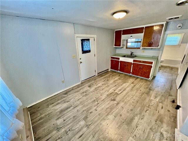 127 S Main St, Lewisburg, OH 45338 - kitchen featuring light wood-type flooring, light countertops, and a baseboard radiator