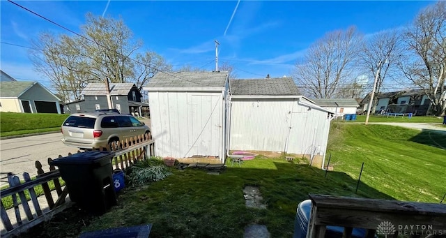 127 S Main St, Lewisburg, OH 45338 - view of side of home featuring a yard, a shingled roof, an outbuilding, and a residential view