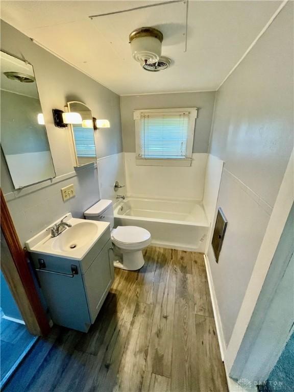 127 S Main St, Lewisburg, OH 45338 - bathroom featuring a bath, wood finished floors, and vanity