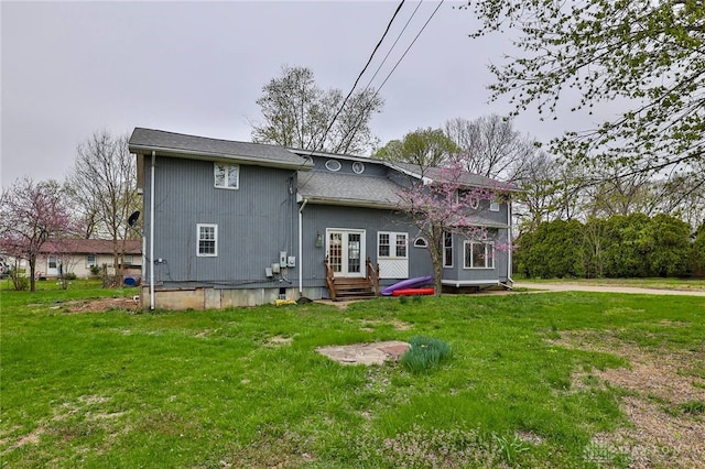 back of property featuring entry steps, french doors, and a lawn