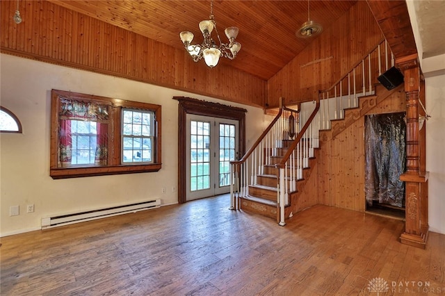 entryway with a baseboard radiator, wood finished floors, an inviting chandelier, and stairway