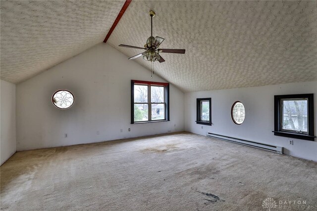 interior space featuring a baseboard heating unit, ceiling fan, carpet floors, and vaulted ceiling