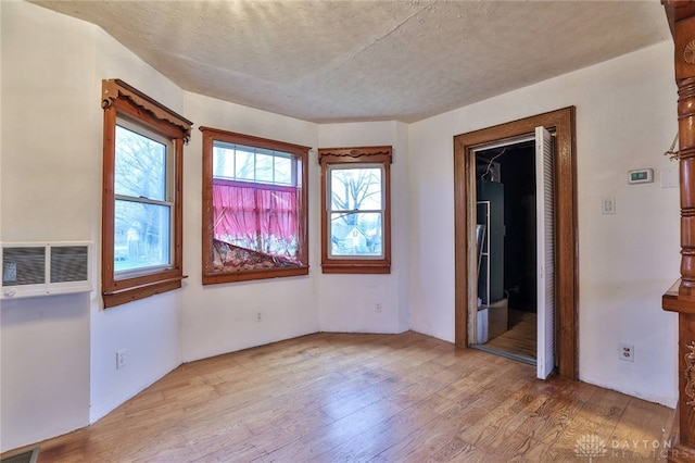 empty room featuring light wood-style flooring, visible vents, and a healthy amount of sunlight