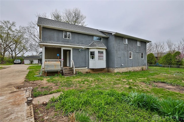 back of property featuring concrete driveway and fence