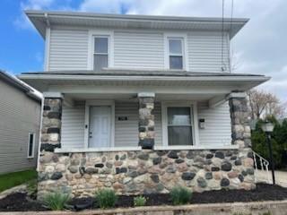 view of front facade with a porch and stone siding