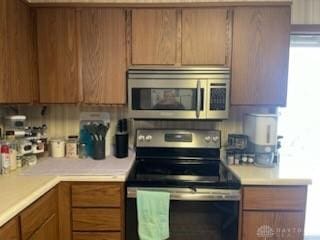 kitchen with brown cabinets, light countertops, and stainless steel appliances