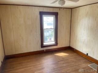 unfurnished room featuring visible vents, baseboards, a ceiling fan, and wood finished floors