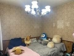 bedroom with a chandelier and wallpapered walls