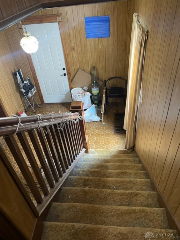 stairway featuring wooden walls and wood finished floors