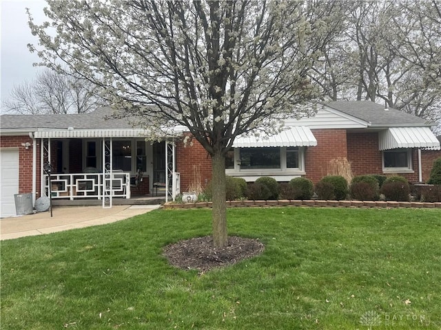 ranch-style house with a front yard, brick siding, and an attached garage