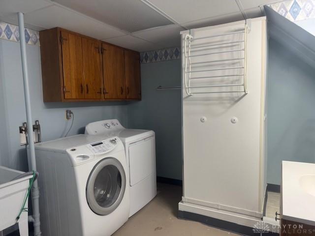 clothes washing area featuring washer and dryer, laundry area, and a sink