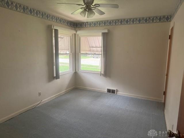 unfurnished room with visible vents, ceiling fan, baseboards, and carpet