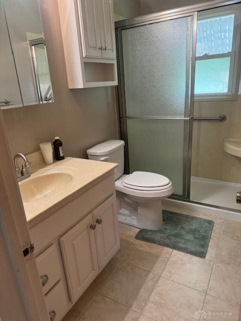 full bathroom featuring a shower stall, toilet, vanity, and tile patterned floors