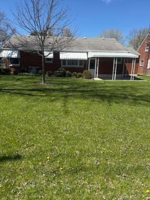 rear view of property with a yard