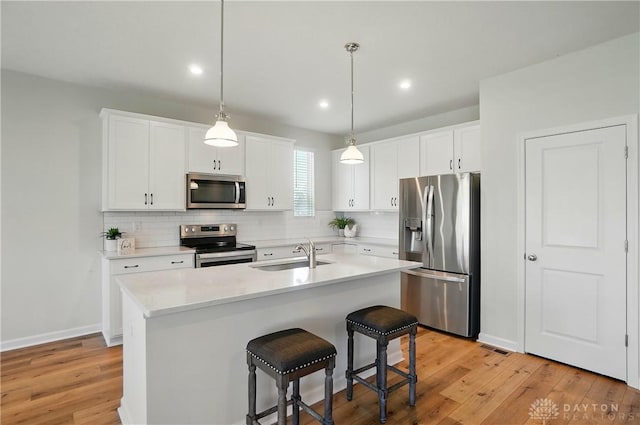 1110 Billingsley Dr, Batavia, OH 45103 - kitchen with tasteful backsplash, a sink, light countertops, light wood-type flooring, and appliances with stainless steel finishes