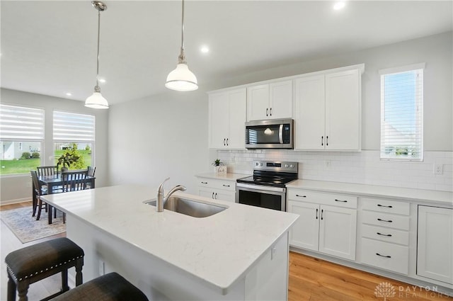 1110 Billingsley Dr, Batavia, OH 45103 - kitchen with stainless steel appliances, tasteful backsplash, light wood-style floors, and a sink