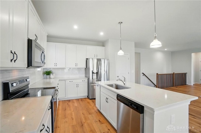 1110 Billingsley Dr, Batavia, OH 45103 - kitchen with light wood-type flooring, white cabinetry, a sink, stainless steel appliances, and backsplash