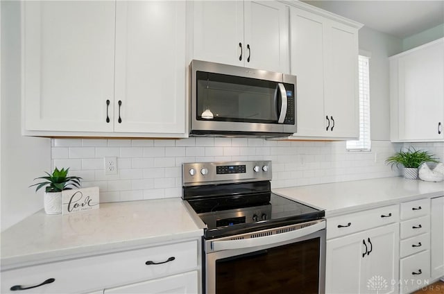 1110 Billingsley Dr, Batavia, OH 45103 - kitchen with white cabinets, backsplash, light stone counters, and appliances with stainless steel finishes