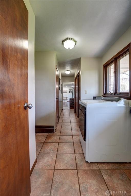 washroom featuring light tile patterned floors, washing machine and dryer, and laundry area