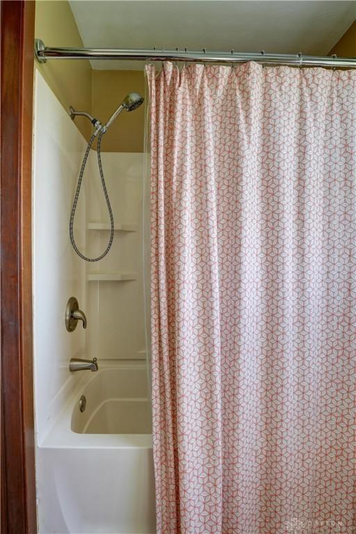 bathroom featuring shower / tub combo with curtain