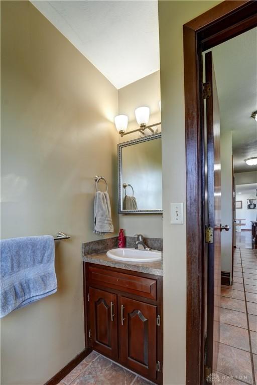 bathroom featuring tile patterned floors, vanity, and baseboards