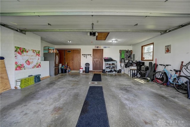 garage with a garage door opener and freestanding refrigerator