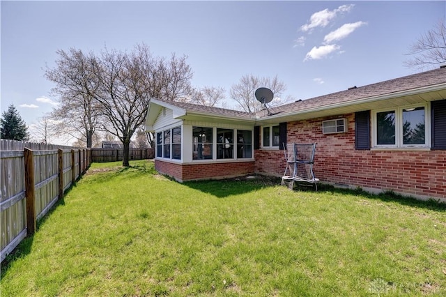back of property with a yard, brick siding, and a fenced backyard