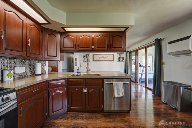kitchen with dark wood-type flooring, a wall mounted AC, a sink, and stainless steel appliances