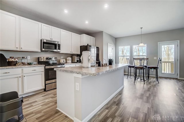 1629 Arden Bnd, Fairborn, OH 45324 - kitchen featuring a kitchen island with sink, light wood finished floors, white cabinetry, and appliances with stainless steel finishes