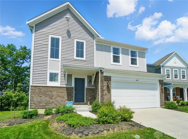 1629 Arden Bnd, Fairborn, OH 45324 - view of front of home featuring brick siding, concrete driveway, board and batten siding, and an attached garage