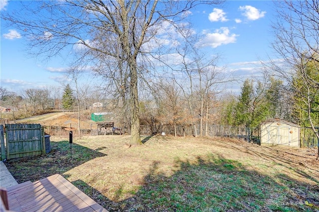 view of yard with a storage shed, fence, and an outdoor structure
