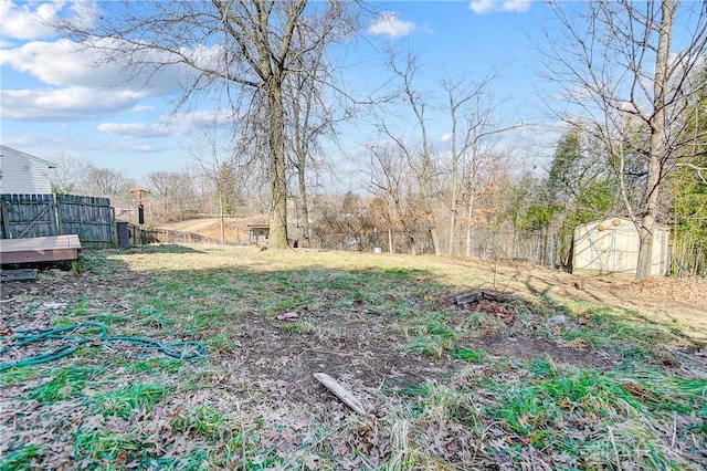 view of yard with an outdoor structure, fence, and a shed
