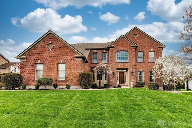 view of front of property featuring a front lawn and brick siding
