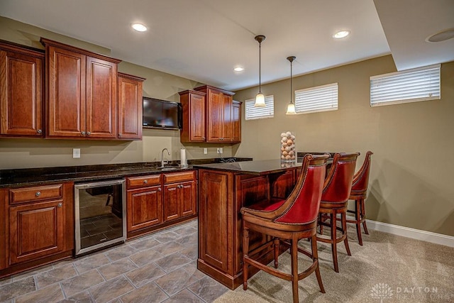 bar with a sink, decorative light fixtures, beverage cooler, and indoor wet bar