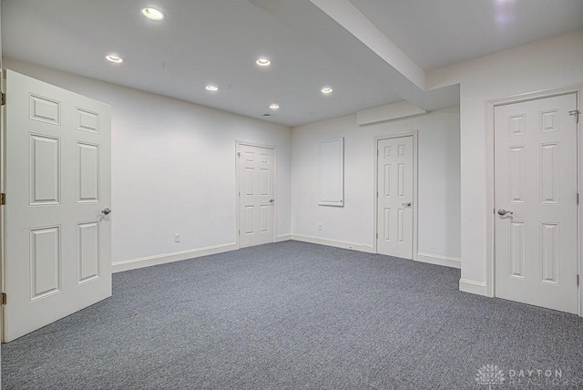 basement with dark colored carpet, baseboards, and recessed lighting