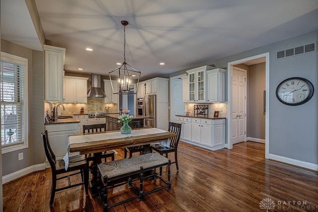 dining space with dark wood finished floors, visible vents, recessed lighting, baseboards, and a notable chandelier