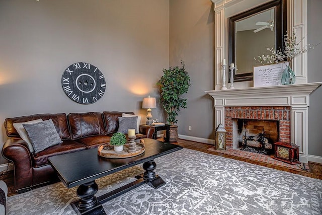 living area with baseboards, wood finished floors, and a fireplace