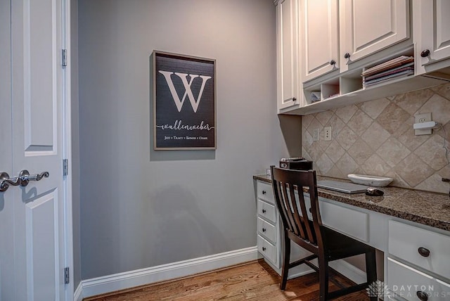 office featuring built in desk, light wood-style flooring, and baseboards