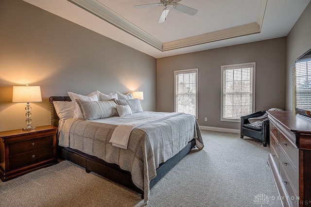 bedroom featuring ornamental molding, multiple windows, a tray ceiling, and light colored carpet