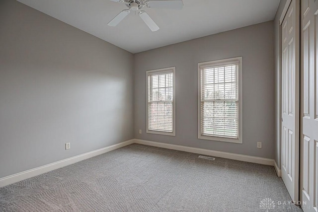 spare room with ceiling fan, visible vents, baseboards, and carpet floors
