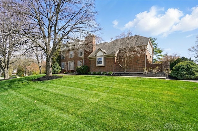 1458 Westwicke Pl, Washington Twp, OH 45459 - view of front of house with brick siding, a front lawn, a gambrel roof, and a chimney