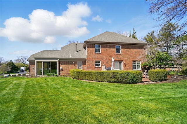 1458 Westwicke Pl, Washington Twp, OH 45459 - rear view of house with brick siding, a sunroom, a lawn, and roof with shingles