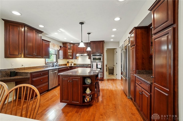 1458 Westwicke Pl, Washington Twp, OH 45459 - kitchen featuring a center island, open shelves, light wood-type flooring, appliances with stainless steel finishes, and under cabinet range hood