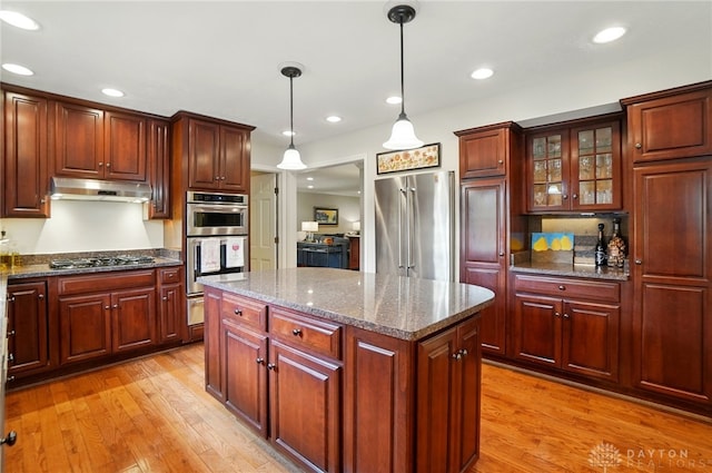 1458 Westwicke Pl, Washington Twp, OH 45459 - kitchen featuring light wood-type flooring, decorative light fixtures, stainless steel appliances, and under cabinet range hood