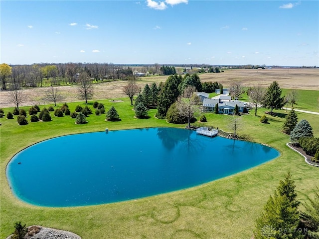 view of swimming pool featuring a water view, a rural view, and a lawn