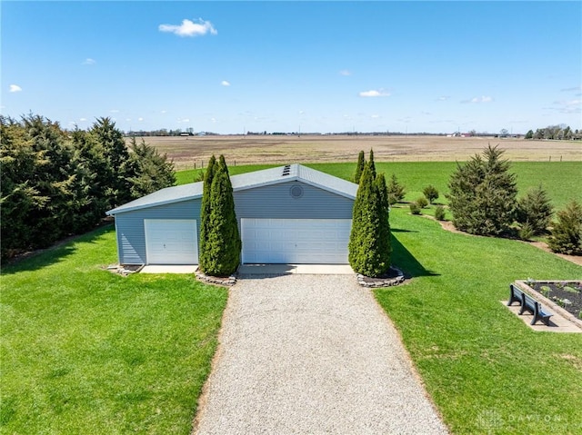 view of front of house featuring a rural view, a front yard, an outdoor structure, and a garage