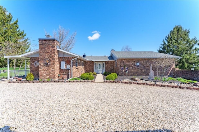 ranch-style home with brick siding, fence, an attached carport, and a chimney